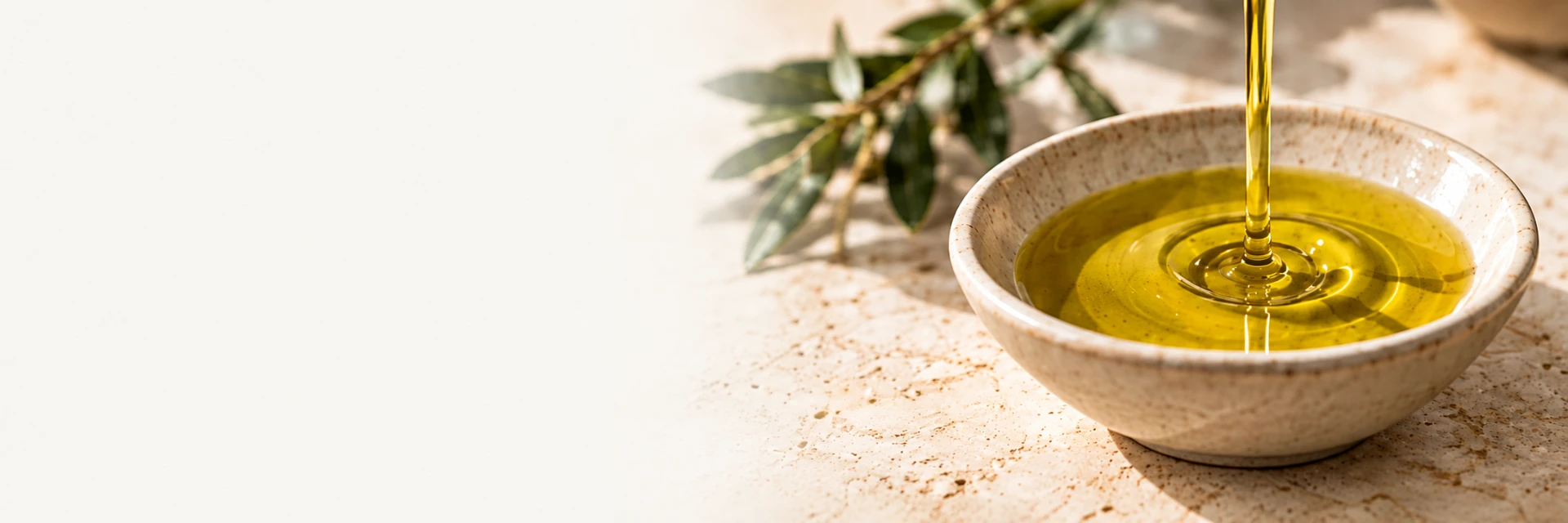 Aceite de oliva cayendo en un cuenco de cerámica